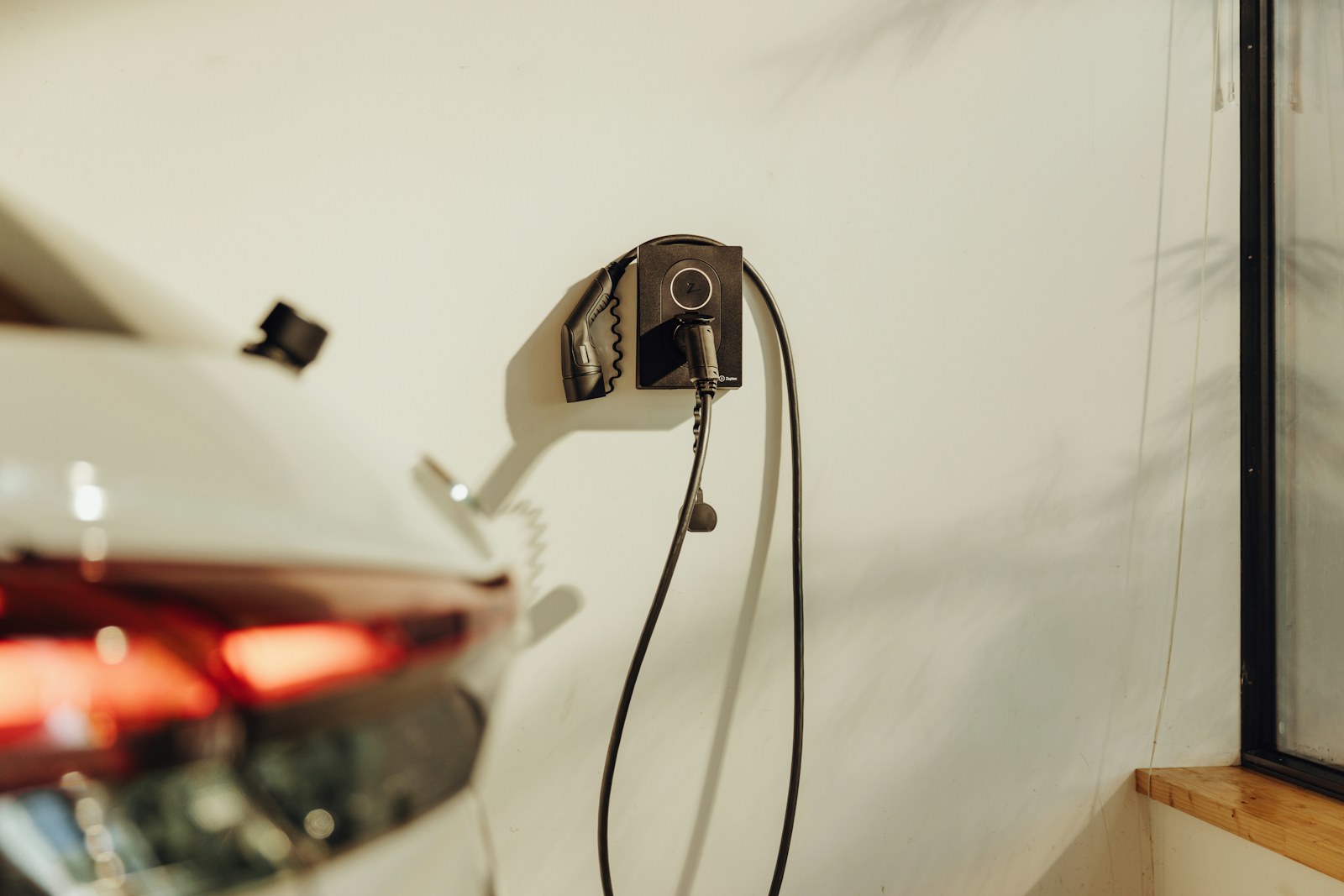 Laadpaal aan de muur met een aangesloten elektrische auto