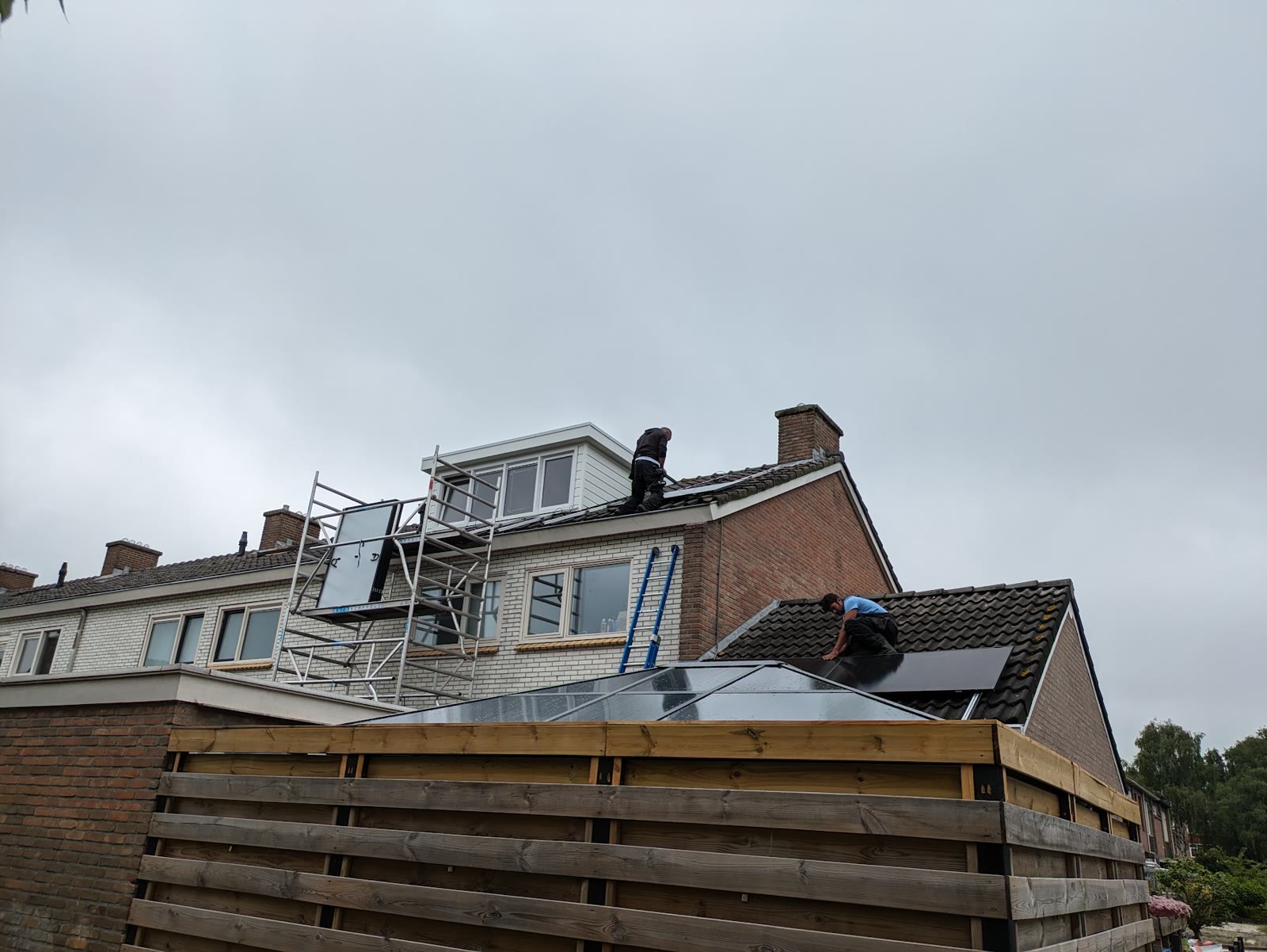 Monteur legt zonnepanelen naast een dakkapel